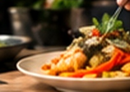 A chef finishing a Thai dish